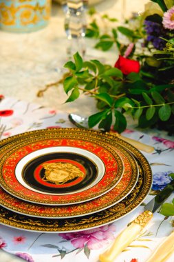 Güzel bir tabak ve mükemmel renkte çiçekler lüks bir masada duruyor.