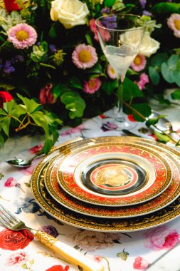 Güzel bir tabak ve mükemmel renkte çiçekler lüks bir masada duruyor.