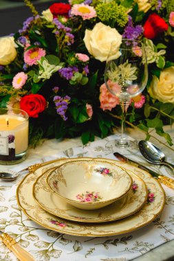 Güzel bir tabak ve mükemmel renkte çiçekler lüks bir masada duruyor.