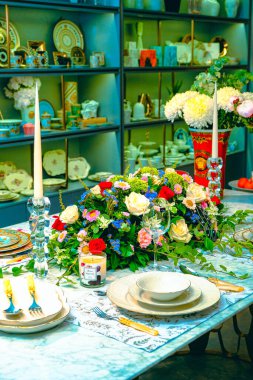 Güzel bir tabak ve mükemmel renkte çiçekler lüks bir masada duruyor.