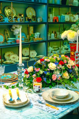 Güzel bir tabak ve mükemmel renkte çiçekler lüks bir masada duruyor.