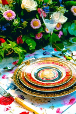 Güzel bir tabak ve mükemmel renkte çiçekler lüks bir masada duruyor.