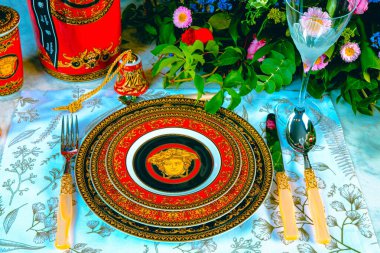 Güzel bir tabak ve mükemmel renkte çiçekler lüks bir masada duruyor.