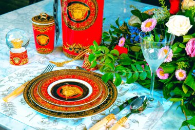 Güzel bir tabak ve mükemmel renkte çiçekler lüks bir masada duruyor.