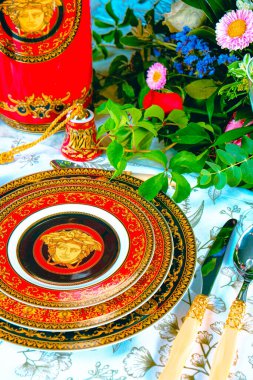 Güzel bir tabak ve mükemmel renkte çiçekler lüks bir masada duruyor.