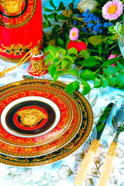 Güzel bir tabak ve mükemmel renkte çiçekler lüks bir masada duruyor.