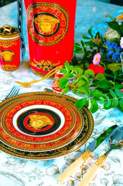 Güzel bir tabak ve mükemmel renkte çiçekler lüks bir masada duruyor.