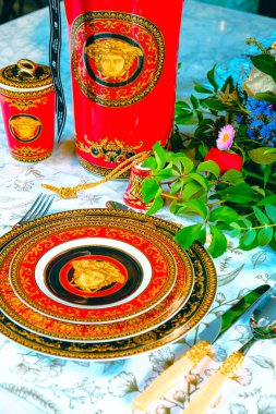 Güzel bir tabak ve mükemmel renkte çiçekler lüks bir masada duruyor.