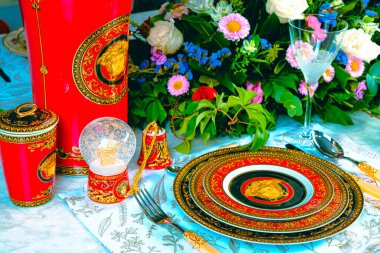 Güzel bir tabak ve mükemmel renkte çiçekler lüks bir masada duruyor.