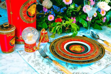 Güzel bir tabak ve mükemmel renkte çiçekler lüks bir masada duruyor.