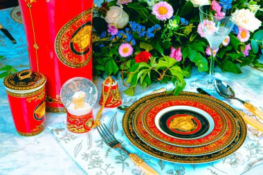 Güzel bir tabak ve mükemmel renkte çiçekler lüks bir masada duruyor.