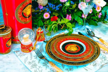 Güzel bir tabak ve mükemmel renkte çiçekler lüks bir masada duruyor.