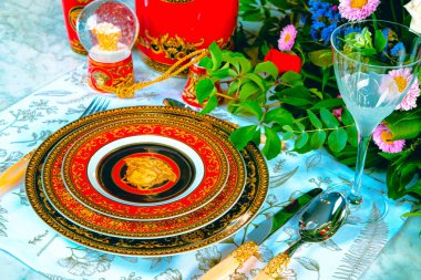 Güzel bir tabak ve mükemmel renkte çiçekler lüks bir masada duruyor.