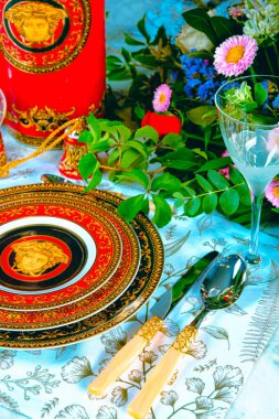 Güzel bir tabak ve mükemmel renkte çiçekler lüks bir masada duruyor.