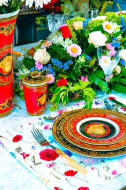 Güzel bir tabak ve mükemmel renkte çiçekler lüks bir masada duruyor.