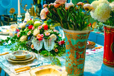 Güzel bir tabak ve mükemmel renkte çiçekler lüks bir masada duruyor.