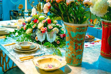 Güzel bir tabak ve mükemmel renkte çiçekler lüks bir masada duruyor.