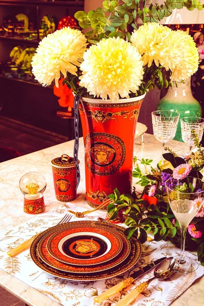 Güzel bir tabak ve mükemmel renkte çiçekler lüks bir masada duruyor.