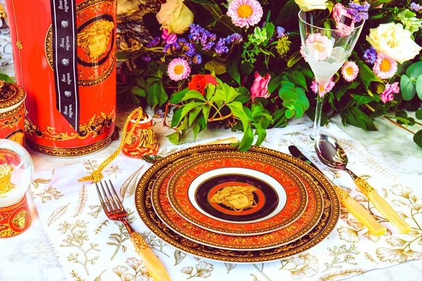 Güzel bir tabak ve mükemmel renkte çiçekler lüks bir masada duruyor.