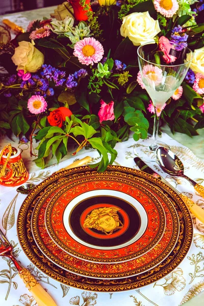 Güzel bir tabak ve mükemmel renkte çiçekler lüks bir masada duruyor.