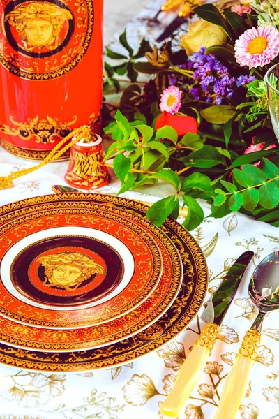 Güzel bir tabak ve mükemmel renkte çiçekler lüks bir masada duruyor.