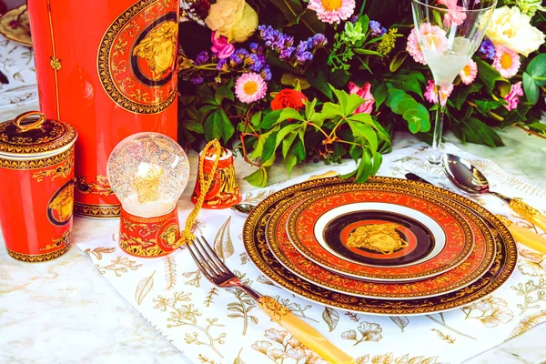 Güzel bir tabak ve mükemmel renkte çiçekler lüks bir masada duruyor.