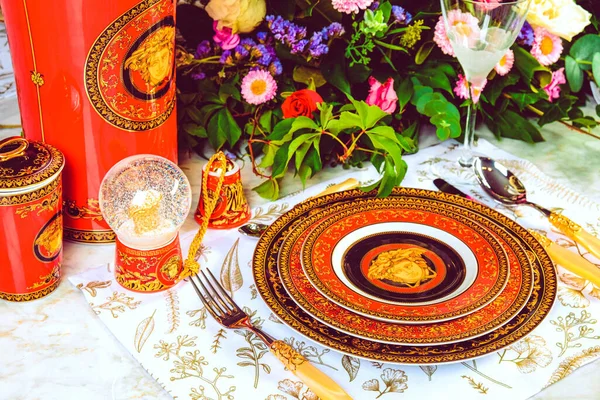 Güzel bir tabak ve mükemmel renkte çiçekler lüks bir masada duruyor.