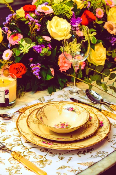 精美的盘子和鲜美的五彩缤纷的花朵矗立在豪华的餐桌上 — 图库照片