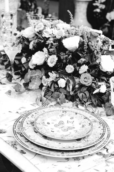 豪華なテーブルの上に立つ美しいプレートと新鮮な完璧なカラフルな花 — ストック写真