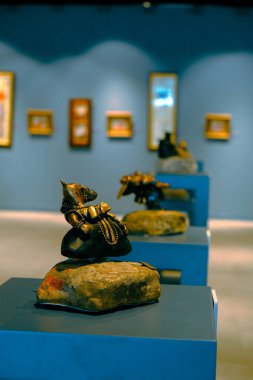 Kadın sergideki eserlere ve sergideki eserlere bakıyor.