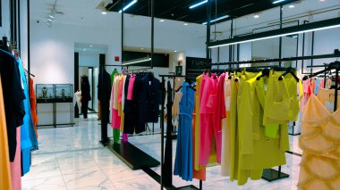 Giysiler mağazadaki rafta asılı.