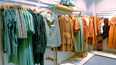 Giysiler mağazadaki rafta asılı.