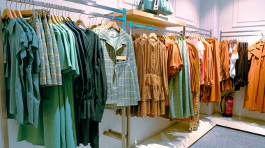 Giysiler mağazadaki rafta asılı.