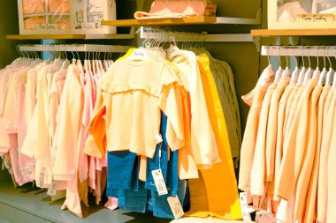 Çocuk kıyafetleri mağazadaki rafta asılı.