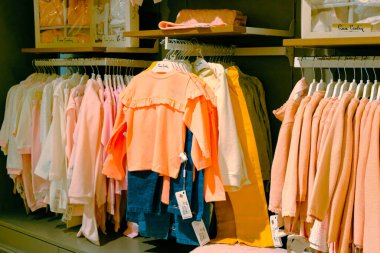 Çocuk kıyafetleri mağazadaki rafta asılı.