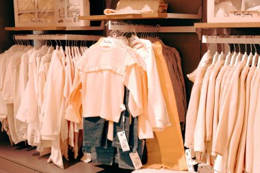 Çocuk kıyafetleri mağazadaki rafta asılı.