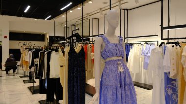 Giysiler mağazadaki rafta asılı.