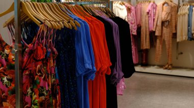 Giysiler mağazadaki rafta asılı.