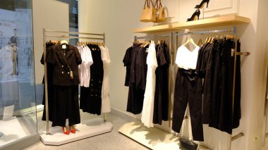 Giysiler mağazadaki rafta asılı.