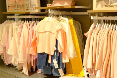 Çocuk kıyafetleri mağazadaki rafta asılı.