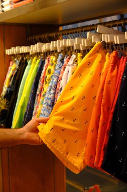 Mağazada kıyafet seçen adam, alışveriş merkezinde alışveriş yapan adam.