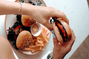 Izgara et, sebze ve sos ile nefis bir burger. Fast food ve abur cubur kavramı.