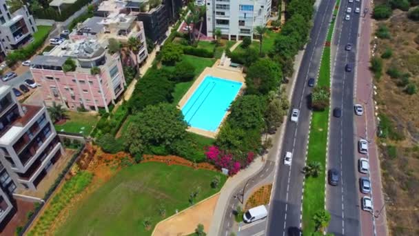 Luchtfoto zwembad zonder mensen omgeven door groene bomen en struiken met prachtige 4k bloemen. Hoge kwaliteit 4k beeldmateriaal — Stockvideo