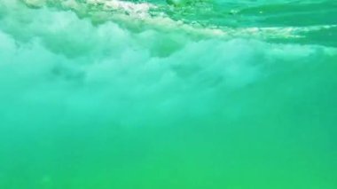 Suyun altında kabarcıklar. Yüzeye yükselen kabarcıklar. Yavaş çekim.