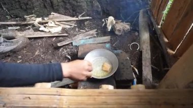 Geleneksel ahşap ocağı kullanarak tuzlanmış balık pişirmek.