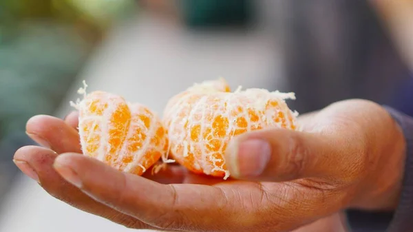 Sweet and ripe yellow orange in hand ready to be served