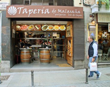 Madrid, İspanya; 10 01 2018. Corredera Alta de San Pablo caddesindeki Malasana barının önünde. Restoranın giriş kapısı ve küçük terasta masa olarak kullanılan variller..