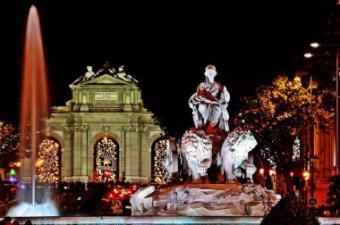 Cibeles Fountain and Puerta de Alcala in Madrid (Spain), illuminated on a Christmas night. clipart