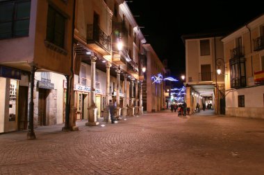 Aranda de Duero, İspanya; 1207 2017. Aranda de Duero, Burgos, İspanya 'da yılbaşı ışıkları olan buğday meydanı. Soğuk bir kış gecesinde insanlar sokaklarda geziniyor..