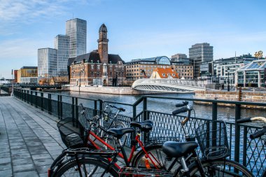 Malmö, İsveç; 02: 15 2016. Bagers Bro Bridge, World Maritime University (WMU) building and Clarion Hotel and Congress in Malmo. Şehir limanının yanındaki bisiklet ve binaların olduğu şehir manzarası.